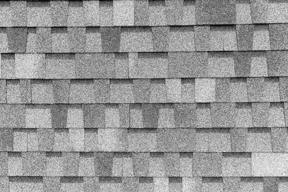 gray architectural asphalt roof shingles close-up showing layered dimensional texture and uniform installation pattern