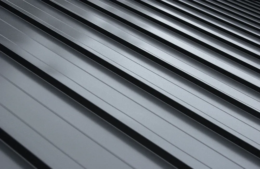 Close-up of ribbed metal roofing panels showing clean lines, strength, and weather-resistant design on a Maine home.