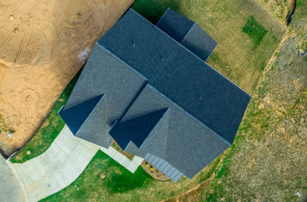 Aerial view of a Maine home with new dark gray shingle roof, showing precise installation and clean roofline design.