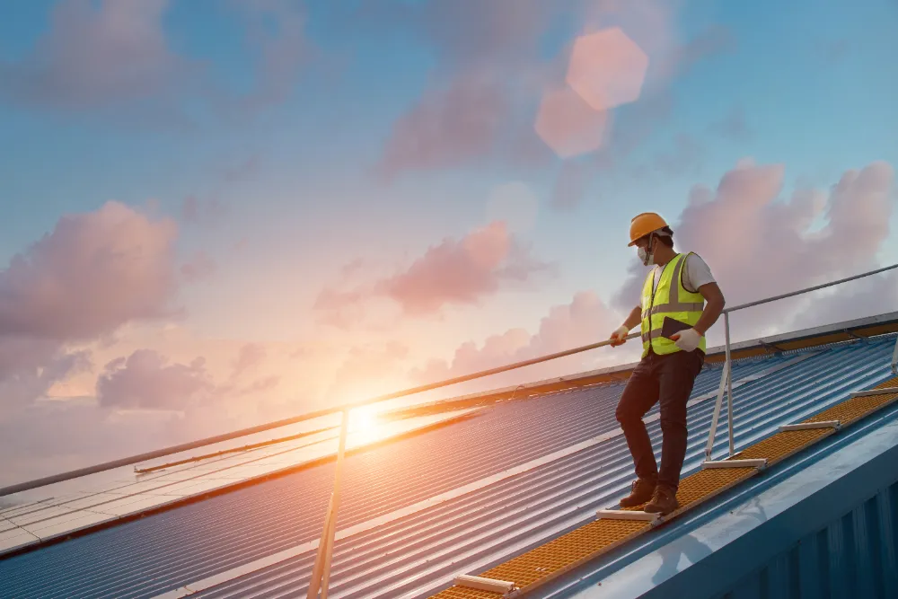 Construction worker carrying a large pipe on-site, representing Restorations Unlimited’s hands-on approach and dedication to helping both new and returning clients build with confidence